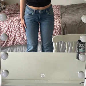 Mörkblå  low/midwaist bootcut jeans i modellen ”Short” - Säljer ett par blå bootcut jeans från Lager 157 i storlek S modell ”short”. Jeansen är low/midwaist! Jätteskönt material med fin passform. Snygg design på bakfickorna