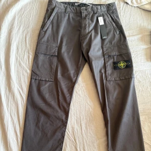Stone island cargo pants - Helt oanvända Stone island cargo pants i  grå, Tag hänger kvar. Beställda från johnells för 3 799,00 kr. Bild på kvitto finns om så önskas, Vid andra frågor är de bara att höra av sig!