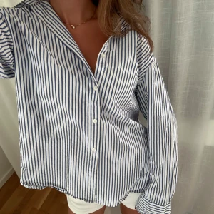 Randig blåvit skjorta  - Snygg oversized skjorta med blå och vita ränder. Vet inte storlek men jag bär vanligtvis XS/S och sitter lagom oversized. 