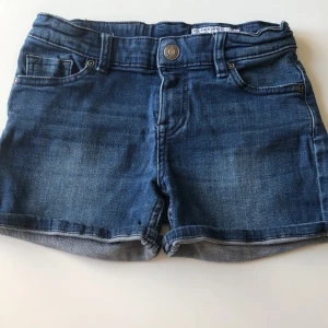 Blå jeansshorts Polarn O. Pyret - Snygga blå jeansshorts från Polarn O. Pyret med klassisk femficksdesign, uppvikta benslut och detaljerade bakfickor. Shortsen har normal passform och är perfekta för varma och soliga dagar. Tidlös denimlook som alltid funkar.
