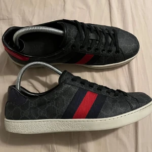 Gucci sneakers med GG-mönster - Snygga svarta sneakers från Gucci med klassiskt GG-mönster, strl 43 mycket bra skick använda fåtal gånger! Box och dustbag ingår hör av er vid frågor😊