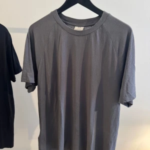 Grå basic t-shirt från Mango - Enkel grå t-shirt från Mango med rund halsringning och korta ärmar. Modellen är rak och har en avslappnad passform, perfekt till jeans eller shorts. Tillverkad i mjuk bomull för en skön känsla hela dagen.