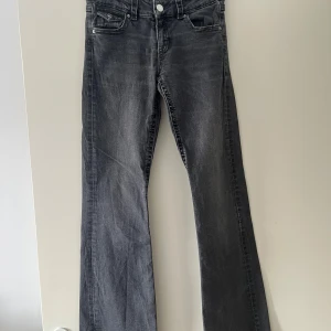 Grå bootcut jeans från Gina Tricot - Snygga grå jeans från Gina Tricot i bootcut-modell. Jeansen har klassisk femficksdesign, coola bakfickor med lock och knapp samt en lätt tvättad look. Dessa jeans är knappt andvända och i ett bra och nytt skick. Perfekta för dig som gillar en avslappnad men trendig stil. Kontakta för fler bilder eller frågor!