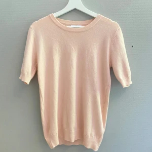 Ljusrosa stickad tröja med kort ärm - Supersöt ljusrosa stickad tröja med korta ärmar och rund halsringning. Perfekt till jeans eller kjol. Mjuk och skön, passar dig som gillar en enkel men söt vibe.