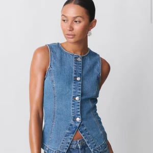 Tailored demin vest - Snygg ärmlös topp i klassiskt blått jeansmaterial med raka linjer och silverfärgade knappar framtill.    Helt ny med prislapp!!!!