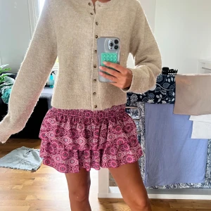 Rosa mönstrad volangkjol - Supersöt kort kjol i rosa med lila och vita detaljer. Passar så bra till allting och varit en favorit hos mig!! Från meetmethere 