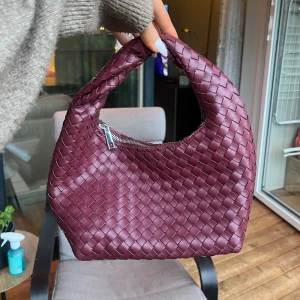 Vinröd flätad handväska  - Säljer en vinröd handväska med flätad design från Gina tricot. I nyskick