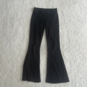 Svarta bootcut leggings - Svarta leggings med bootcut. Stretchigt och mjukt material som sitter skönt och formar sig efter kroppen. Perfekta för en chill och trendig look. Säljer pågrund av att de inte längre passar. 