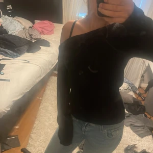 Svart offshoulder  - Säljer en svart stickad tröja med offshoulder-design och långa ärmar. Tröjan har en loose passform och är perfekt för dig som gillar en avslappnad men ändå snygg stil. Enkel att matcha med jeans eller kjol för en cool look.