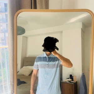 Randig pikétröja från Calvin Klein Jeans - Snygg pikétröja från Calvin Klein Jeans i ljusblå och grå nyanser. Tröjan har ett randigt mönster och knappar framtill. Perfekt för en avslappnad stil med en touch av elegans.