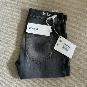 Dondup George jeans - Säljer nu ett par helt nya Dondup George jeans. Färgen på jeansen är grå vilket är en väldigt eftertraktad färg som kan vara svår att få tag på. Storlek W31 och längden på jeansen från midjan och ner är 103 cm. Passformen är skinny fit vilket ungefär motsvarar slim fit. Om du har några funderingar så är det bara att fråga på! ❇️