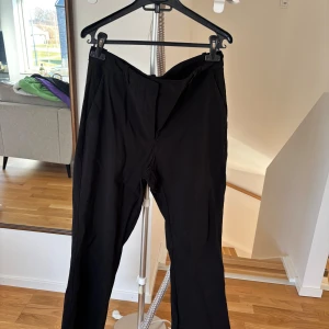 Svarta byxor - Säljer ett par svarta byxor med en klassisk design. Byxorna har en rak passform och är tillverkade i ett lätt och bekvämt material. Perfekta för en stilren look. Super stretchiga kostym aktiga. Använda en gång 