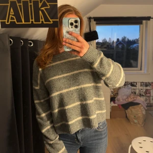 Stickad tröja med randigt mönster - Säljer min gosiga stickade tröja från Hm divided. Tröjan är grå och randig med vita linjer. Perfekt för en elegant men ändå basic outfit🩶tröjan är i storlek M men den passar på XS och mig som har storlek! nypris: 250kr