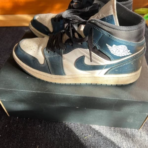  Air Jordans 1 mid  ”Dark Teal” - Air Jordan 1 Mid som har synliga tecken på användning. Snygg färg kombination🔥rätt så sliten då tån börjat släppt, sulan innuti har börjat få tecken på slitag samt crease skydd. Annars är den väll lite smutsig men blir jävligt snygg om man gör rent den till sommarn!💯kartong medföljes samt priset är diskuterbart vid snabb affär!