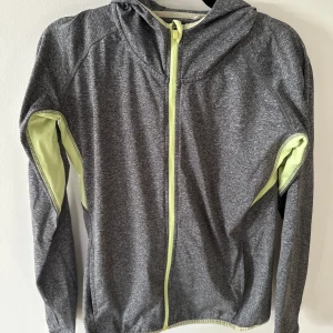 Träningströja - Grå långärmad träningströja med limegröna detaljer och luva.