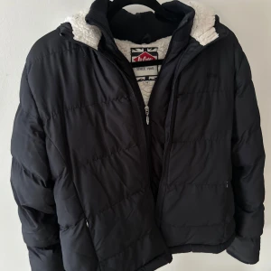 Vinterjacka  - Mörk marinblå jacka med varmt innerfoder och dubbla dragkedjor framtill. Använd, men är i bra skick. Står i jackan att storleken är uk 14 och eu 42, men skulle säga att uppfattas med som en stl m.