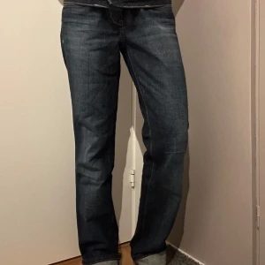 Mörkblå jeansbyxor - Snygga mörkblå jeansbyxor med en klassisk design. De har en rak passform och är perfekta för en avslappnad stil. Byxorna har en dragkedja och knapp framtill.