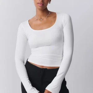 Gina soft tröja  - Snygg vit långärmad topp med tight passform och rund halsringning. Perfekt för lager-på-lager eller att bära som den är. Enkel och stilren design som passar till många olika outfits.