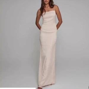 Balklänning med öppen rygg - Jättefin cremefärgad balklänning i sidenmaterial med öppen rygg och smala axelband! Använd en gång 