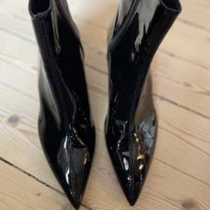 Helt nya, svarta lackade stövletter från Zara - Snygga svarta stövletter i lack med spetsig tå och dragkedja. 
