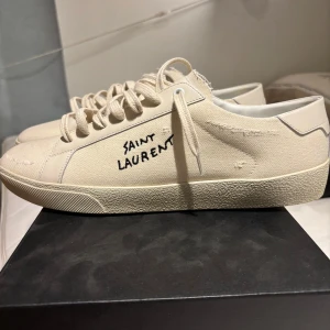 Vita sneakers från Saint Laurent - Tjaaaa!😁👍Säljer mina helt nya SL/06 som inte har använts en ända gång. Säljer på grund av storleken för stora för mig. Nytt pris runt 8000 kr. Allt kommer med, kvitto 2 dustbags och låda, skosnören osv. Hör av er om ni undrar något om ni vill ha blir bilder eller så. Priset kan sänkas vid snabb affär.