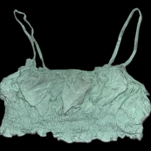 Mint/turkos linnetopp - Snygg mint/turkos linnetopp med smala axelband och rynkade detaljer. Perfekt för varma sommardagar. Toppen har en croppad passform som ger en trendig look.