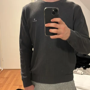 Grå/brun tröja från GANT - Säljer en stilren grå/brun tröja från GANT. Tröjan har en rund halsringning och långa ärmar med ribbade muddar. Perfekt för en avslappnad och snygg look. Passar bra till både jeans och chinos. Väldigt lite använd och inga defekter. Hör av er vid funderingar 