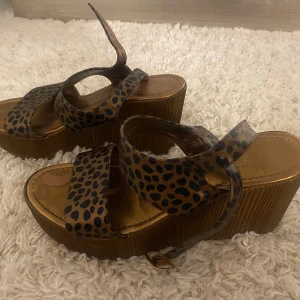 Leopardmönstrade sandaler med platå - Snygga sandaler med leopardmönster och breda remmar. Platåsulan ger extra höjd och stil. Perfekta för att sätta en trendig touch på din outfit.