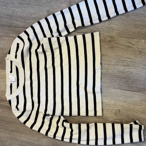 Randig tröja från Gina Tricot - Säljer en stilren randig tröja från Gina Tricot i svart och vit. Tröjan har långa ärmar och en ribbad struktur som ger en skön passform. Perfekt för en avslappnad look. 🖤🤍