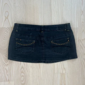 Vintage Svart mini jeanskjol  från Denim Co - svart kort jeanskjol från Denim Co med låg midja och detaljer i gult på bakfickorna. Det var mammas gamla från 90-talet ❤️ 42 men sitter som M