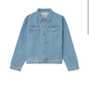 Ljusblå jeansjacka från LisBonne NY med lappar - Klassisk ljusblå jeansjacka från LisBonne med raka linjer, två bröstfickor med knappar och sidofickor. Jackan har knäppning framtill och vid ärmslut, samt en liten gulddetalj på ryggen. Perfekt för dig som gillar en clean och tidlös look.