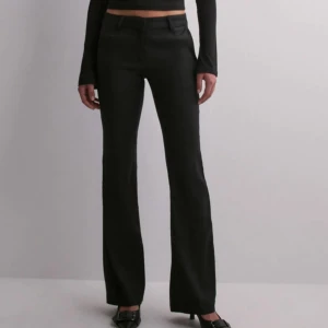 Svarta linne kostymbyxor  - Snygga svarta kostymbyxor från Nelly med hög midja och vida ben. Perfekta för dig som gillar en dressad men trendig stil.