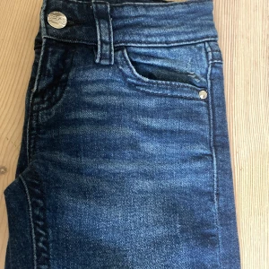 Blå jeans från Gina Tricot, stl 146 - Mörkblå jeans från Gina Tricot med snygga detaljer på bakfickorna. Jag har använt dom en gång så dom är dom nya.