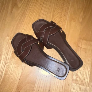 Bruna sandaler med korsade remmar - Snygga bruna sandaler från H&M med korsade remmar och vita sömmar. Fina till sommaren. Använda en gång 🥰