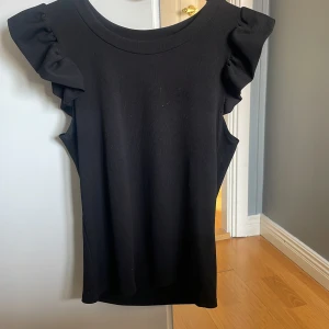Svart  topp med volang - Svart topp med volang från Missay. Står inte någon storlek men skulle säga S-M, använd få gånger.