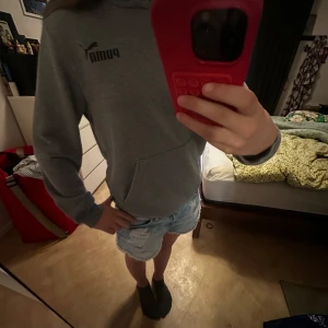 Grå hoodie från Puma med huva - Säljer en grå hoodie från Puma med klassisk logga på bröstet. Tröjan har huva, magficka och ribbade muddar vid ärmslut och nederkant.  Säljer pågrund av att jag inte fått användning 💕💕