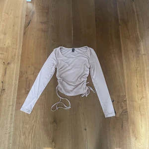 Ljusrosa långärmad topp med snörning vid sidan - Fin ljusrosa långärmad topp från shein med snörning i sidorna. 