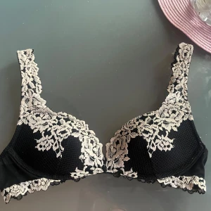Svart spetsbh med blommigt mönster - Svart intimissimi bh med vit broderad spets och blommigt. Storlek 70 B. Används få gånger, är i bra skick.