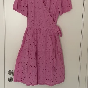 Rosa omlottklänning med broderi från Y.A.S - Superfin rosa kortklänning med omlottmodell och knyt i midjan. 🌸✨🌸 Knappt använd.