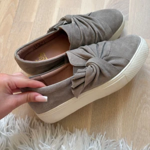 Beige mockasneakers med rosett från Dasia - knappt använda, säljer endast då de är för stora för mig!!