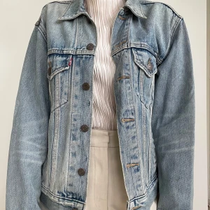 Levi's ljusblå jeansjacka XS - Klassisk ljusblå jeansjacka från Levi's i storlek XS. Jackan har bröstfickor med knappar, sidfickor och snygga kontrastsömmar. Tillverkad i slitstarkt denim med knappstängning framtill och krage.