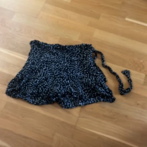  Kjol med inbyggda skjorta från Zara - Supersöt svart kort från Zara med vita prickar. Kjolen har knytband i midjan och en lätt volangkant nertill. Den har inbyggda skjorts. Storleken är M men skulle säga att den är S eller XS.