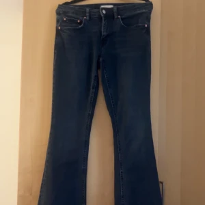 Mörkblå bootcut jeans - Snygga mörkblå jeans med bootcut passform och klassisk femficksdesign. Jeansen har normal midja och är tillverkade i ett mjukt denimtyg som ger en skön känsla. Perfekta för dig som gillar en retroinspirerad look med utsvängda ben. Använd 1 gång 