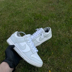 👟 Det Nike Dunk Low – Grå & Vit - 👟 Det Nike Dunk Low – Grå & Vit 📏 Storlek: 41 EU 💸 Pris: 425 kr 🧾 Nypris: Ca 1 200–1 400 kr  ✨ Skick: Skorna är i superfint skick – inga skador, repor eller märken. Använda försiktigt och är fortfarande fräscha med mycket liv kvar i både sula och ovandel.  🎨 Design & färg: Klassisk Nike Dunk Low i grå och vit färgkombination – stilren och lätt att matcha med vilken outfit som helst. Perfekta både till vardag och streetwear-look.