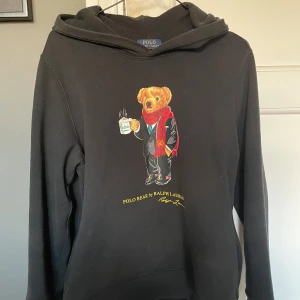 Ralph Lauren Polo Hoodie - En snygg och bra behandlad svart hoodie från Ralph Lauren. Har använt den ett par gånger men sedan bara varit i garderoben. Det är barnstorlek men passar Xs/S. Köpte den för 2500kr