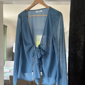 Blå transparent blus med knyt framtill från NA-KD - Så fin blus där bilderna inte gör rättvisa