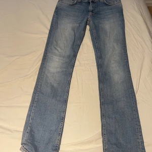 Blå jeans från Nudie Jeans - Säljer ett par klassiska blå jeans från Nudie Jeans med raka ben och normal passform.Modellen är Thinn Finn .Säljer pga att de inte passade mig!. Men annars riktigt feta enligt mig. Bara att höra av er om ni har några funderingar. Obs man får endast jeansen och inget annat.