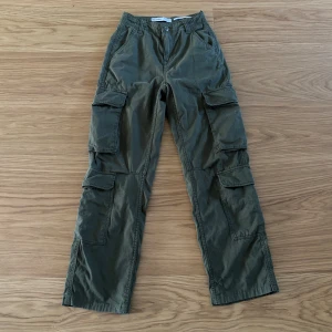 Cargobyxor - Bershka - Sparsamt använda cargobyxor från Berhska som inte säljs längre. Ett hål i högra byxbenet som fanns när de köptes (se sista bilden). Ord. pris: ca 400 kr.