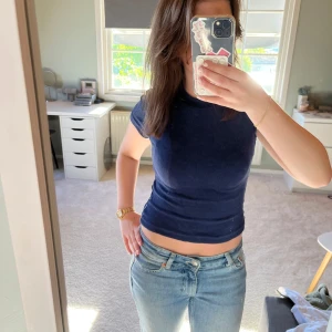 Mörkblå tight t-shirt - Säljer en mörkblå tight t-shirt med korta ärmar. Enkel och stilren modell som passar perfekt till jeans eller kjol. Materialet är mjukt och stretchigt.