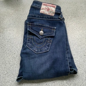 Mörkblå jeans från True Religion - Lågmidjade mörkblåa jeans ifrån True religion. Dom är knappt använda och i väldigt bra skick. Dom är i storlek 23 och modellen Joey. (Om du ska köpa via instabox så hör gärna av dej först för kan ta någon dag extra innan jag postar då för bor inte så nära någon instabox men om du köper med PostNord så kan jag troligtvis posta samma dag som du köper) 